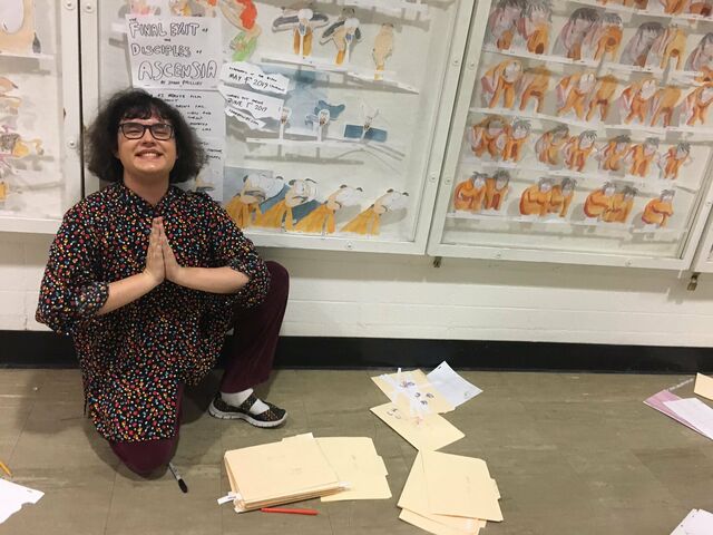 Jonni Phillips, surrounded by The Final Exit of the Disciples of Ascensia art at her alma mater, CalArts.