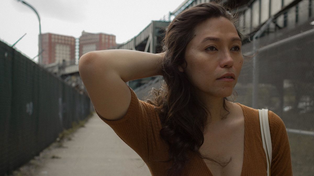 screencap from lingua franca movie with main character looking off to the right with hand behind her head