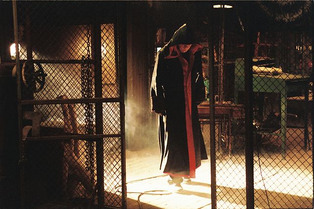 Lurking in the shadows, Tobin Bell in his first appearance as Jigsaw.
